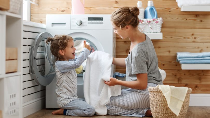Mother Daughter Doing Laundry Chore Together