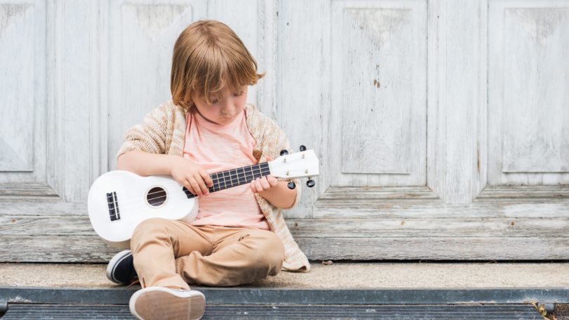 Happy Boy Playing White Guitar