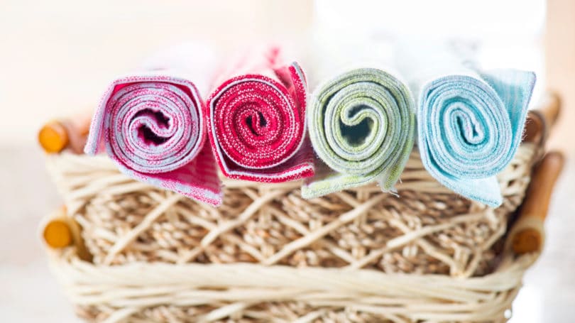 Colorful Dish Towels Rolled Up Over Wicker Basket