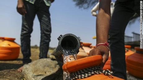 Water commuters fill containers at a groundwater source in Latur, Maharashtra, India, in 2016. 