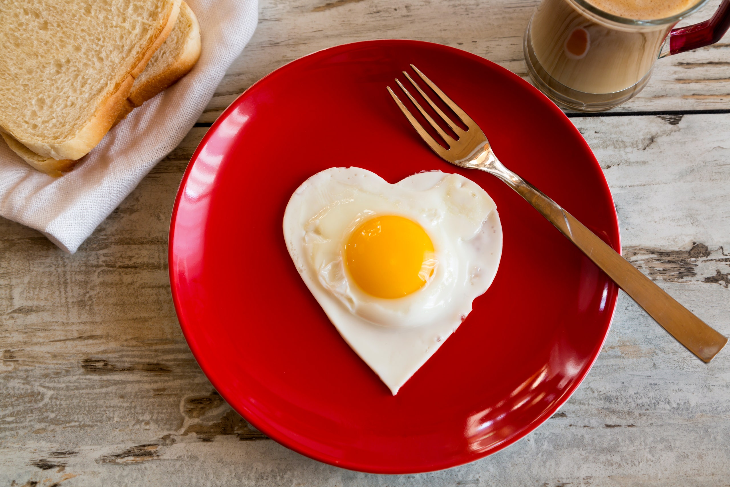 A heartshaped egg on a red plate
