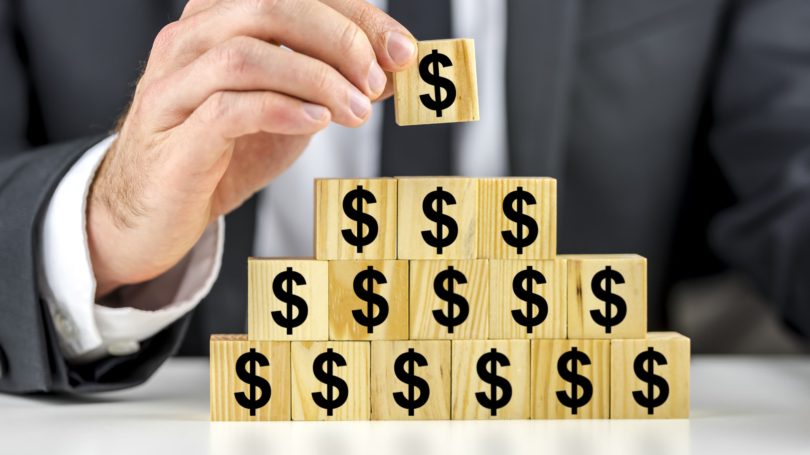 Businessman Stacking Blocks With Dollar Signs Pypramid Scheme